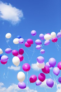 Holiday balloons on blue sky background.